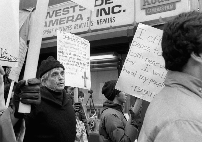 This April 9, 1982, file photo shows Daniel Berrigan, a Roman Catholic priest and Vietnam war protester, marching with about 40 others outside of the Riverside Research Center in New York. AP phot